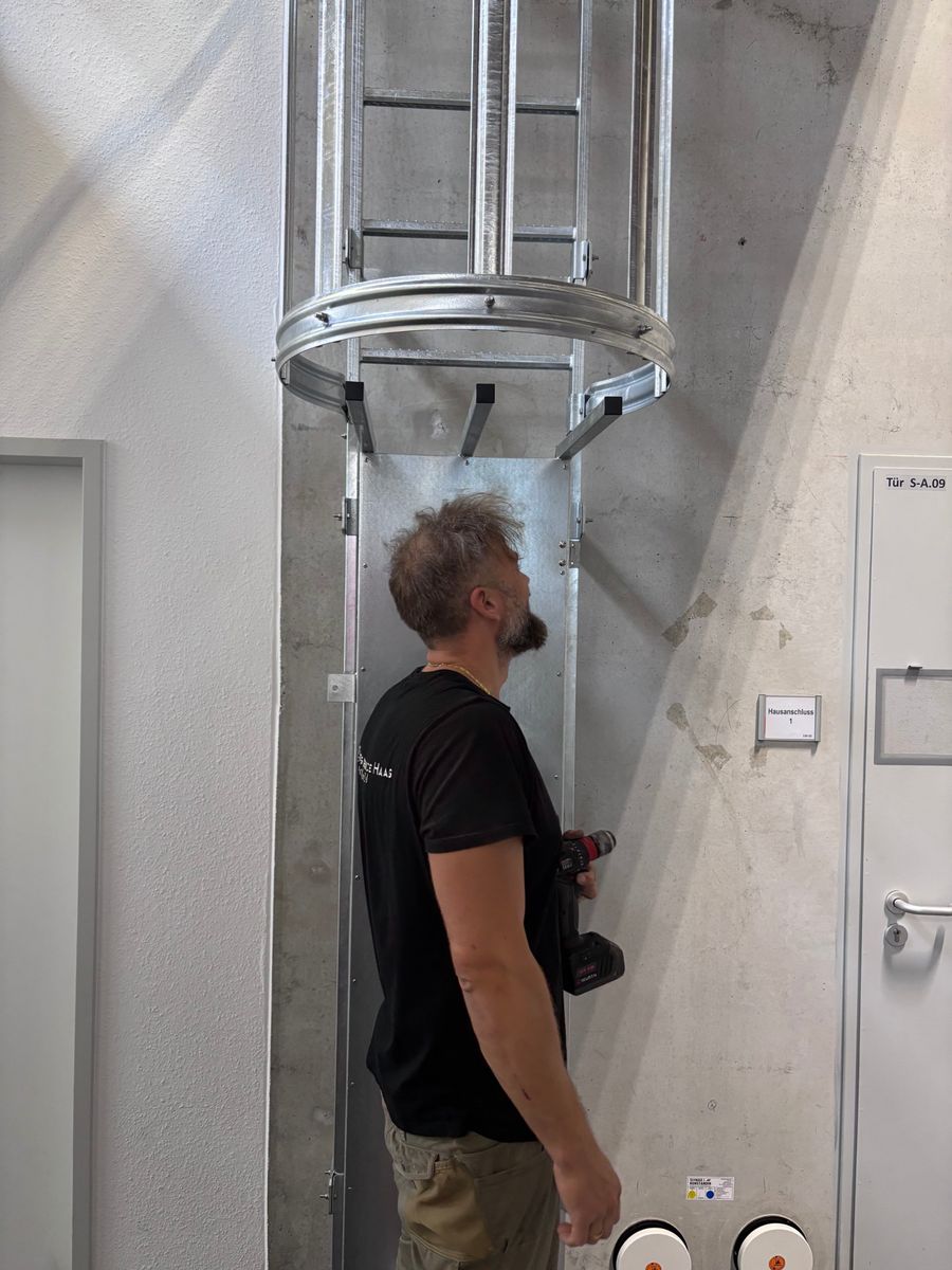 Montage einer Steigleiter mit Rückenschutz